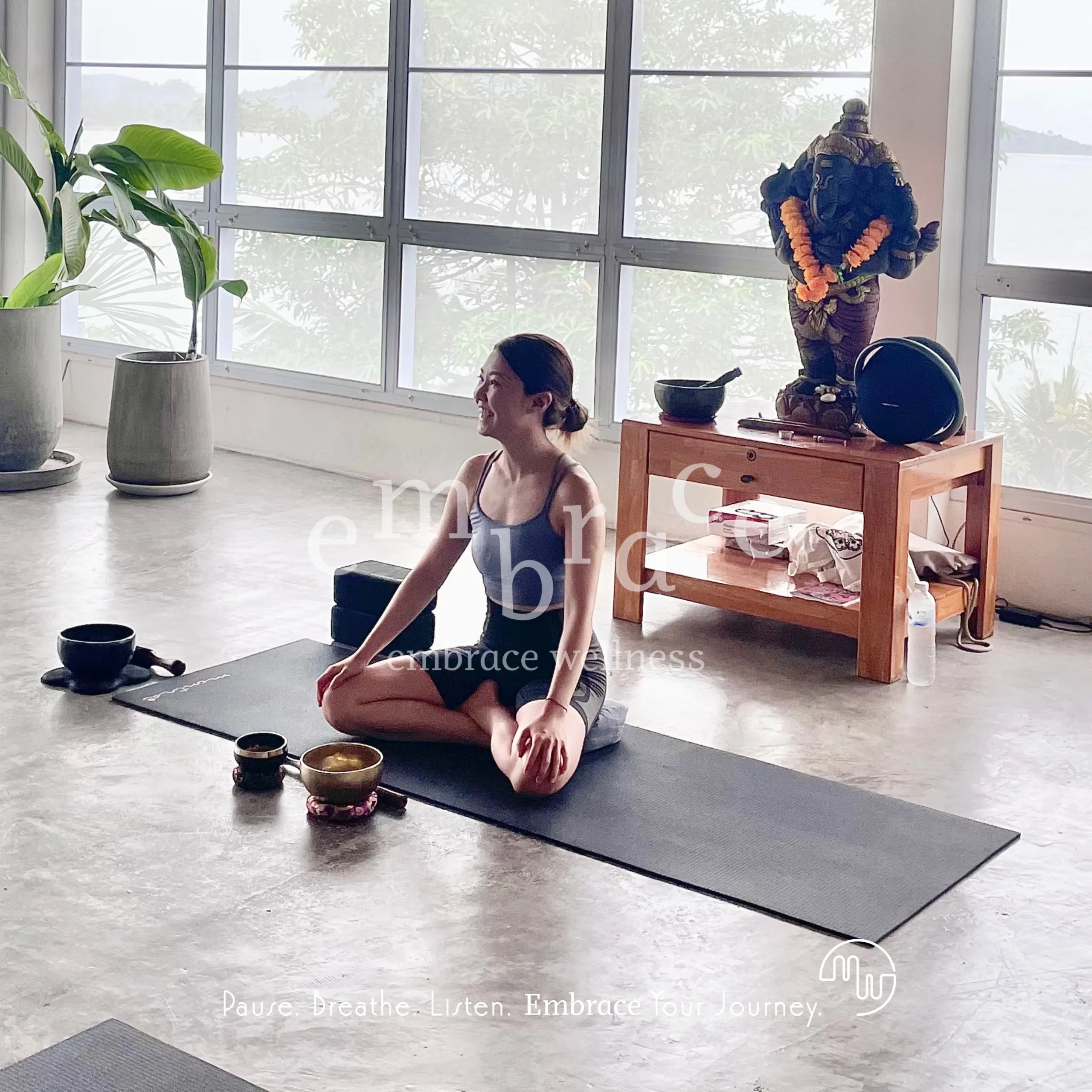 Manlee W seated on a yoga mat in a serene wellness studio with Tibetan singing bowls – small group yoga classes Newbury