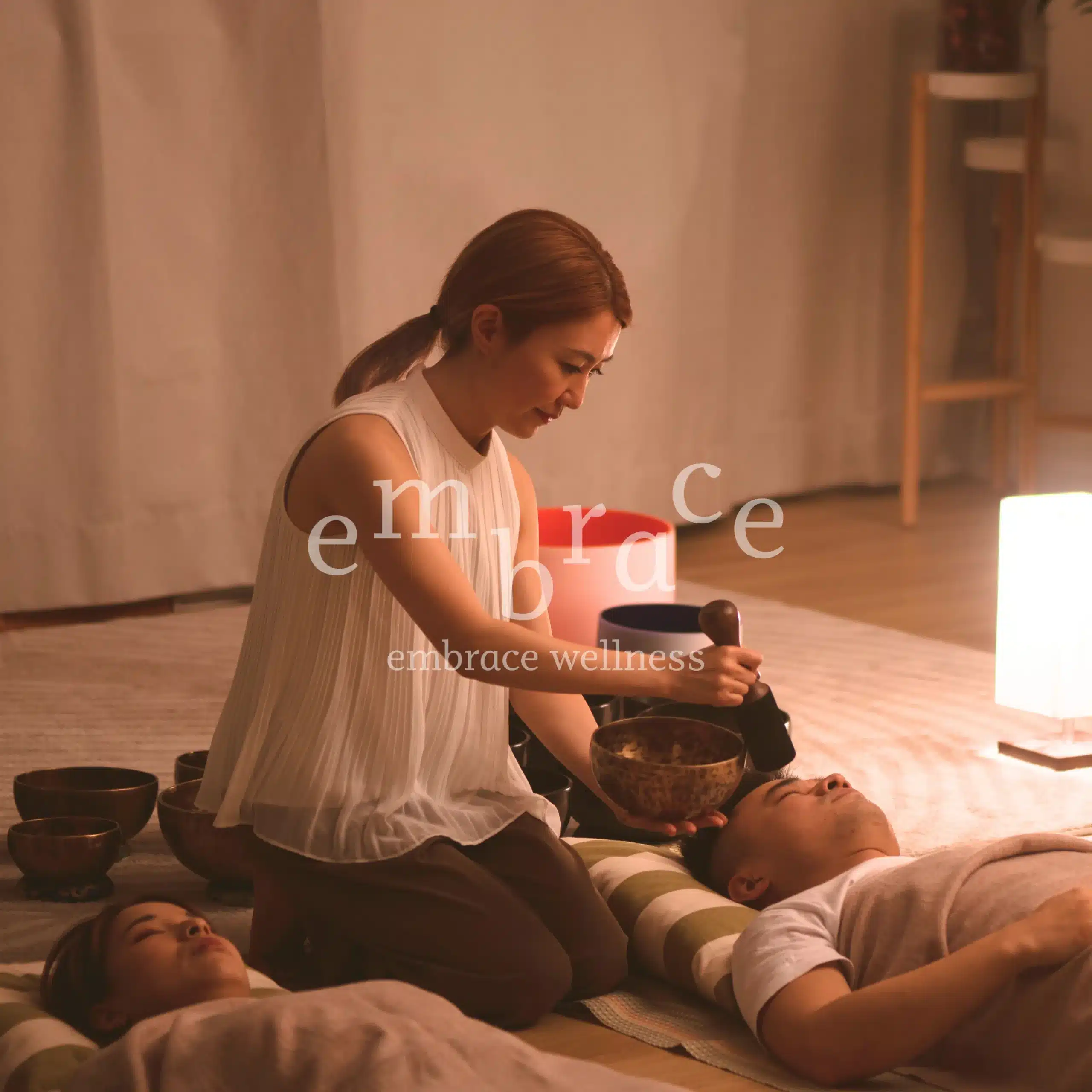 Certified sound healer Manlee performing a Tibetan singing bowl sound bath for relaxation and holistic wellness at Embrace Wellness, Newbury, guiding participants towards a transformative journey.