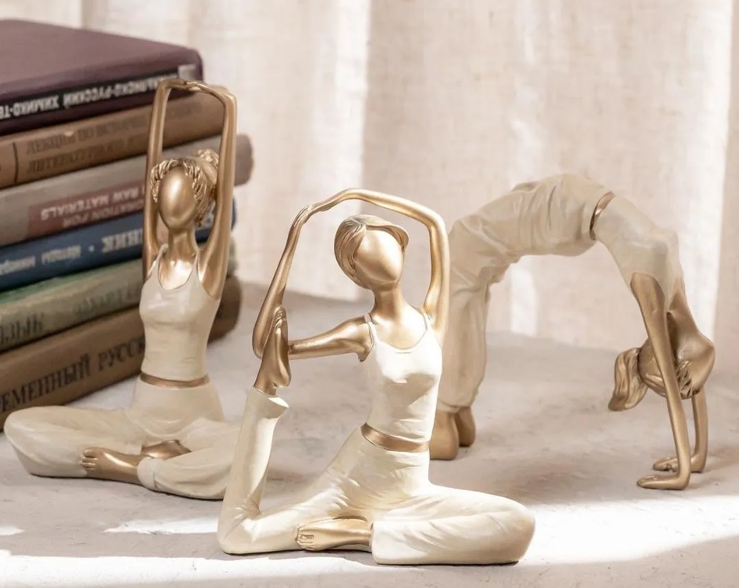 Elegant gold and ivory yogi figurines in serene yoga poses, ideal for mindful home decor and relaxation.
