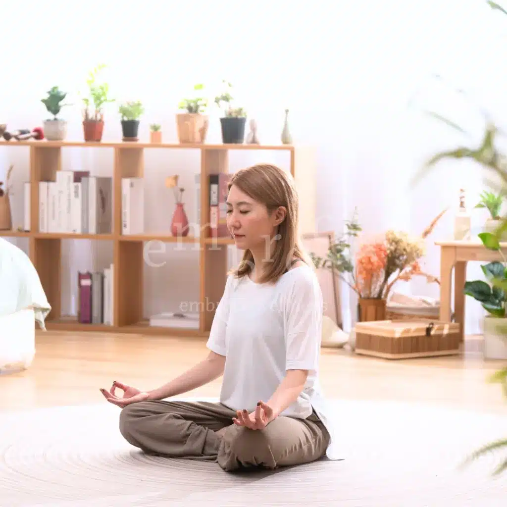 Wellness coach Manlee W practicing mindful breathwork and meditation in a peaceful home studio, representing yoga and wellness with Embrace Wellness in Newbury, Berkshire