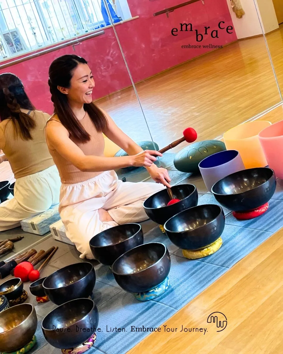 Experienced sound healer Manlee W joyfully playing crystal singing bowls and Tibetan singing bowls during Sound Bath in Newbury, Berkshire – Embrace Wellness